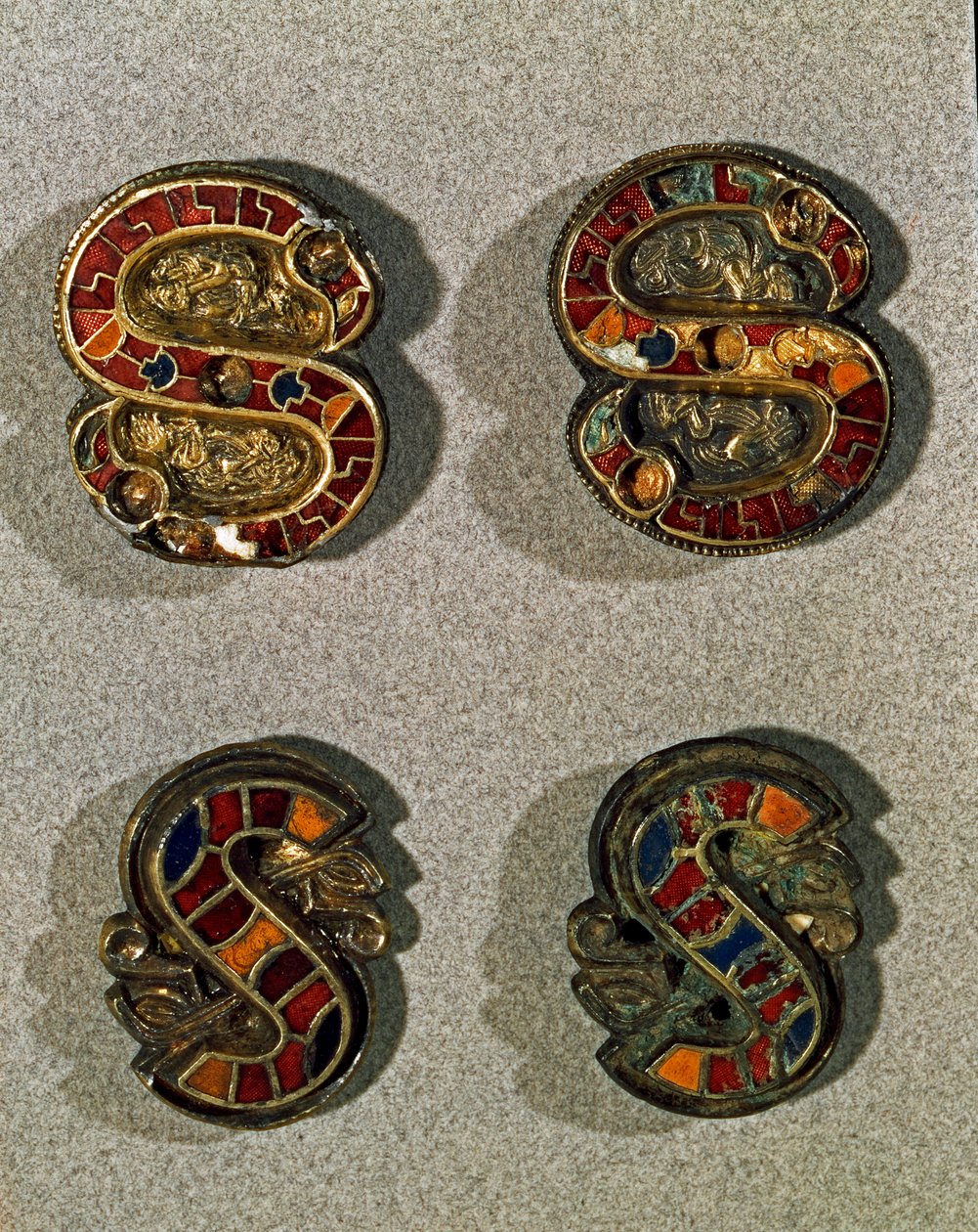 Keskiajan arkeologia (keskiaika). Lombardian barbaaritaide: S-kirjaimen muotoinen vyön fibule (solki). Esine kultaa ja moniväristä emalia. Lombard-taide, 6. - 7. vuosisata. Italia, Cividale del Friuli, Arkeologinen museo tekijältä School Lombard