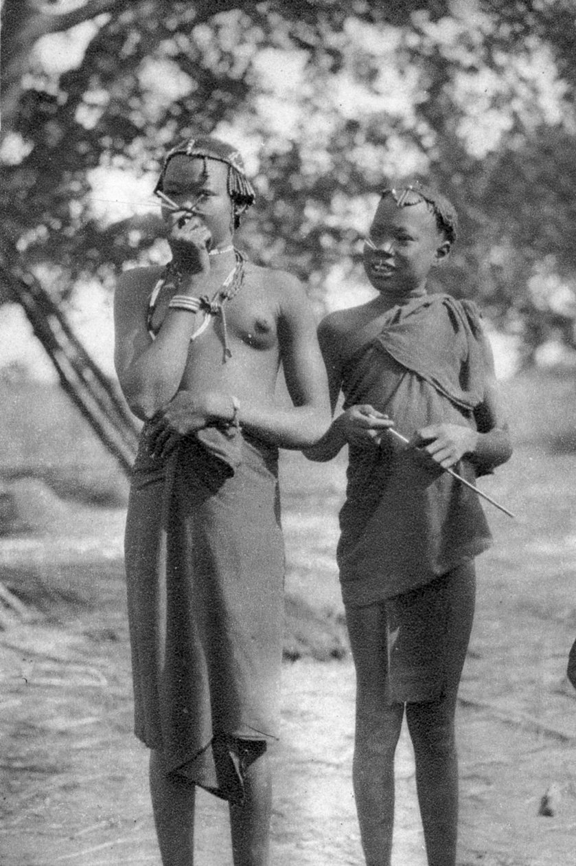 Nuoret tytöt tikkuja nenässä ja huulissa, Terrakekka Aweiliin, Sudan, 1925 1927 tekijältä Thomas A. Glover