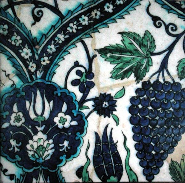 Iznik-laatta, jossa on kukkia ja rypäleterttu (keramiikka värillisellä aluslasilla) tekijältä Turkish School