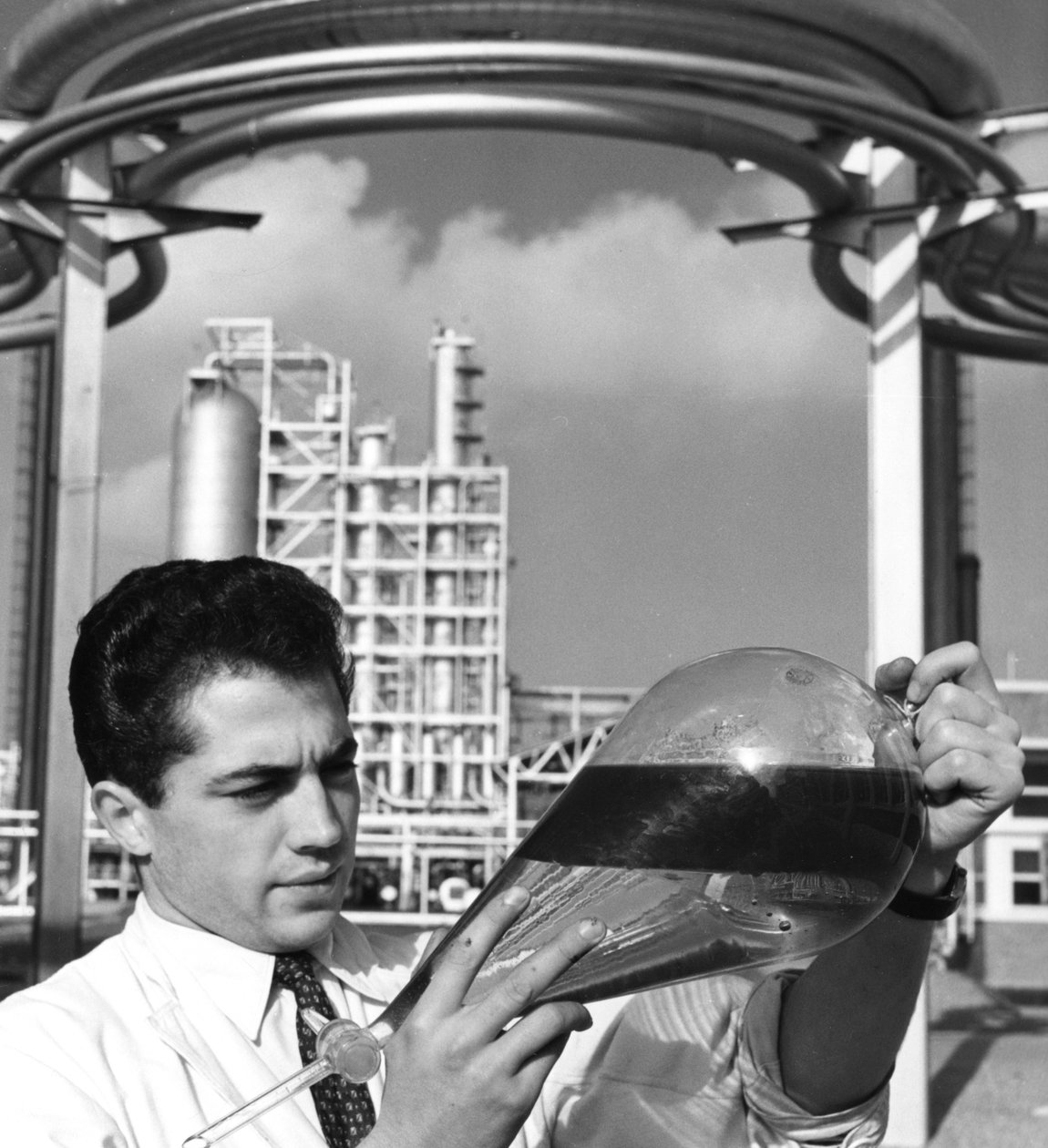 Laboratoriotyöntekijällä on erotussuppilo öljyä, Dunkerquen jalostamo, Ranska, 1950-luku tekijältä Unbekannt