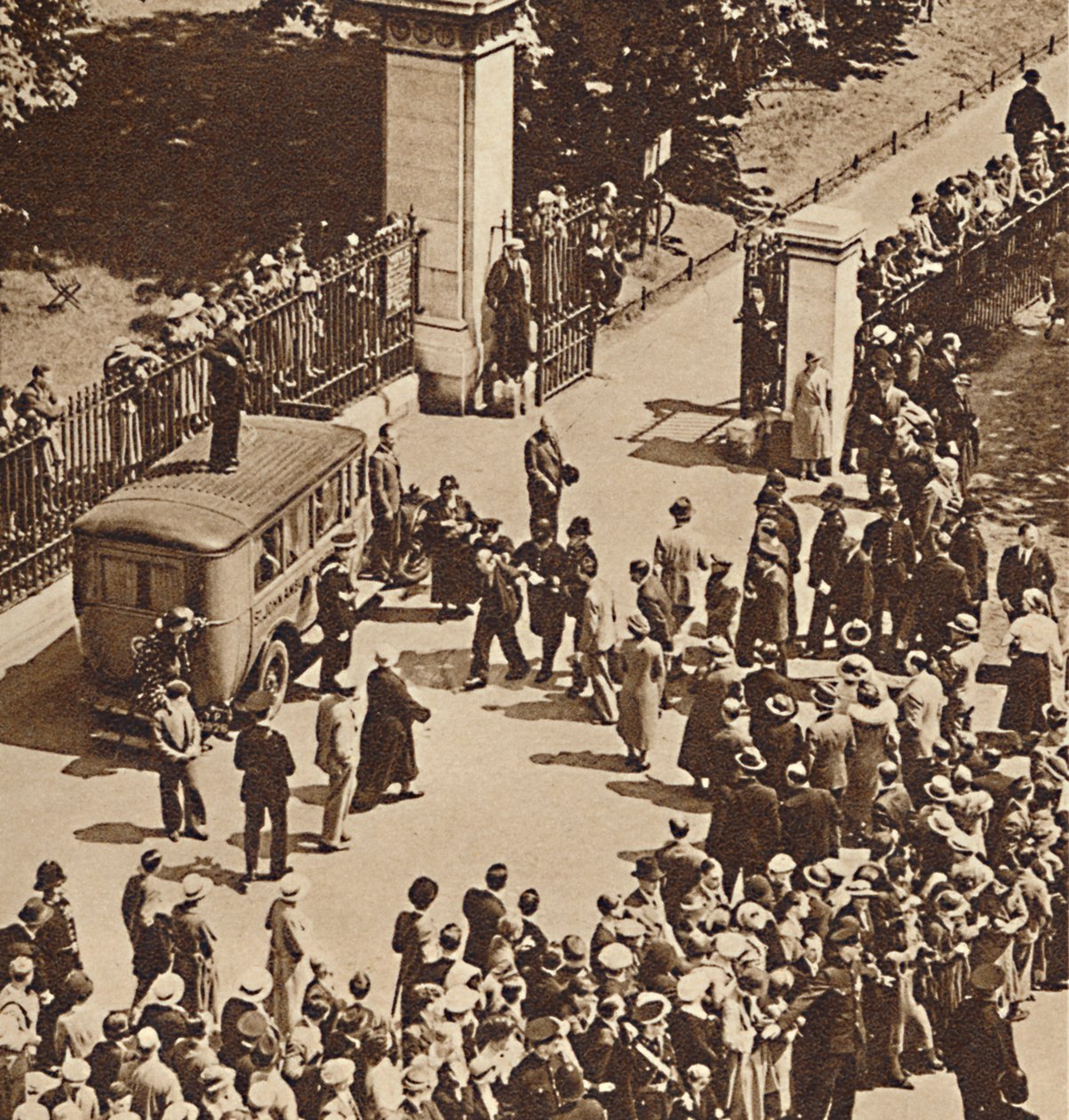 Yleisö katselee pidätettyä miestä, joka viedään poliisiautoon vuonna 1937 tekijältä Unbekannt