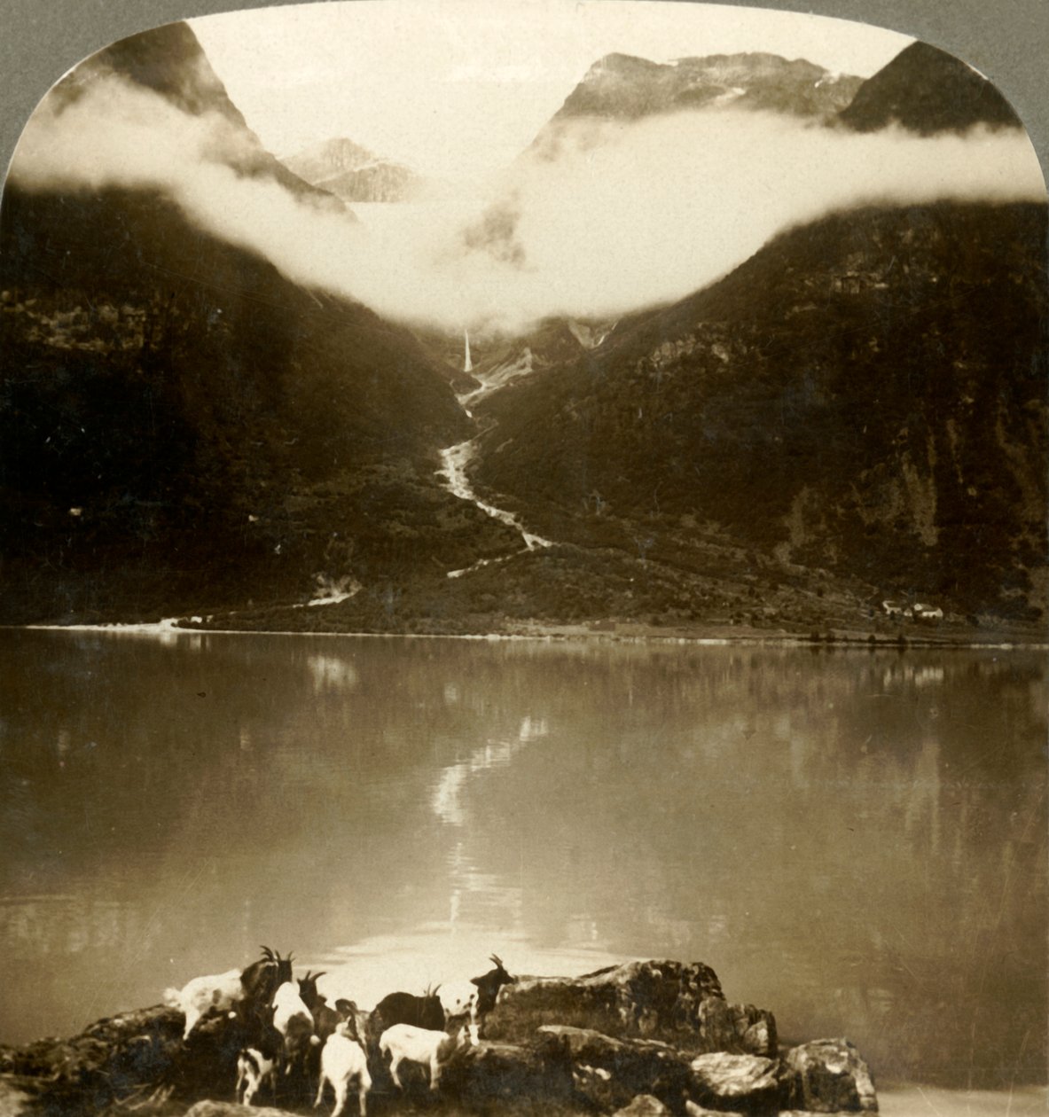 Grytereids-jäätikkö kimaltelee ajelehtivien pilvien yllä rauhallisen Olden-järven yli, Norja, 1905. tekijältä Unbekannt