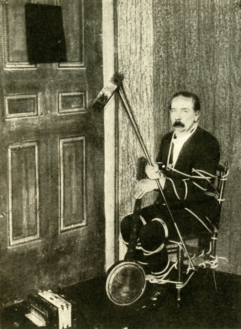 John Nevil Maskelyne esittää henkikaapin illuusion, v. 1910. tekijältä Unbekannt