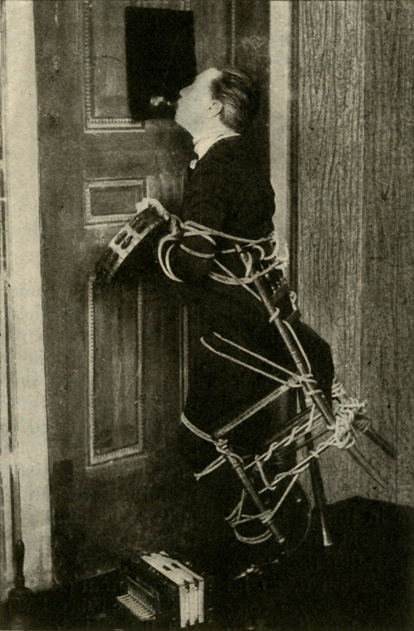 John Nevil Maskelyne esittää henkikaapin illuusion, v. 1910. tekijältä Unbekannt