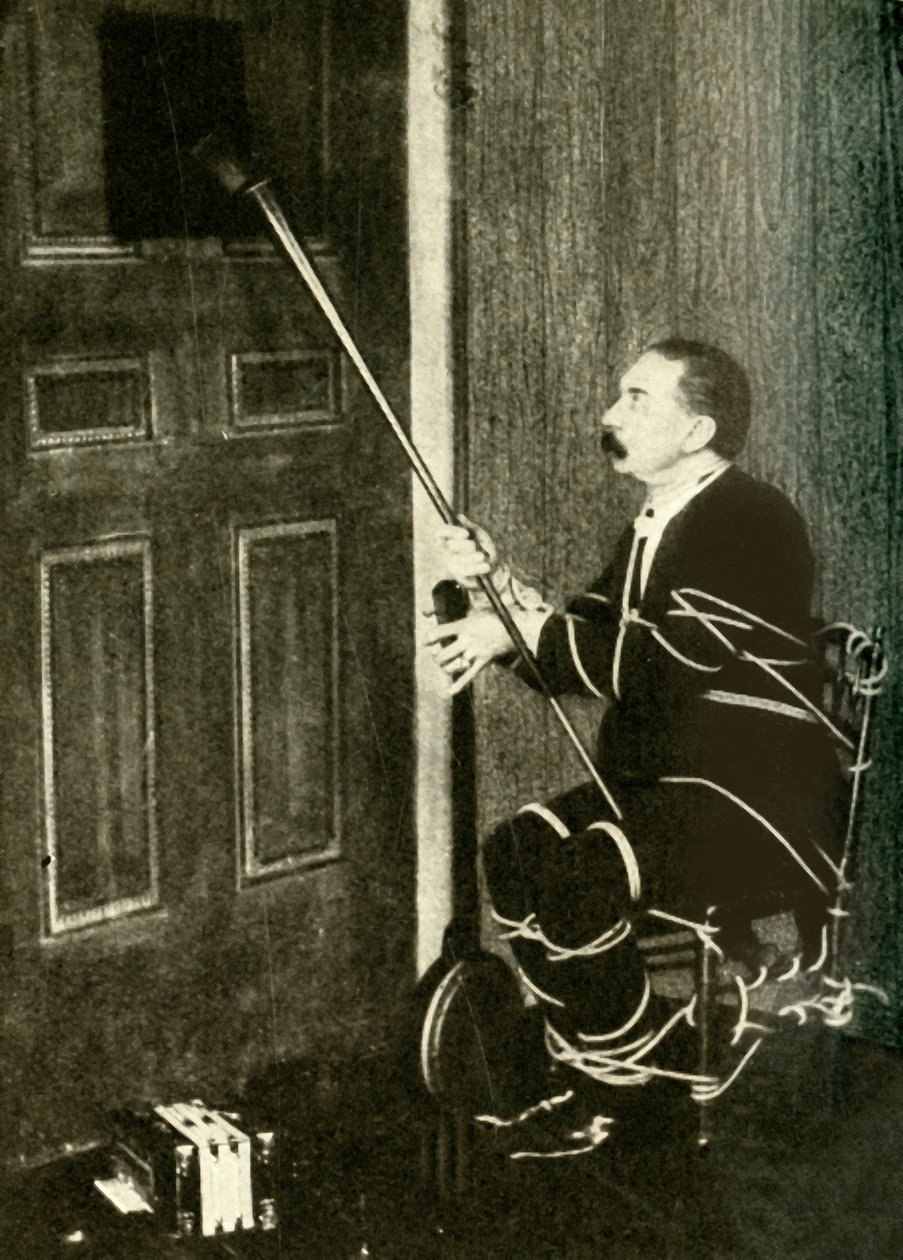 John Nevil Maskelyne esittää henkikaapin illuusion, v. 1910. tekijältä Unbekannt