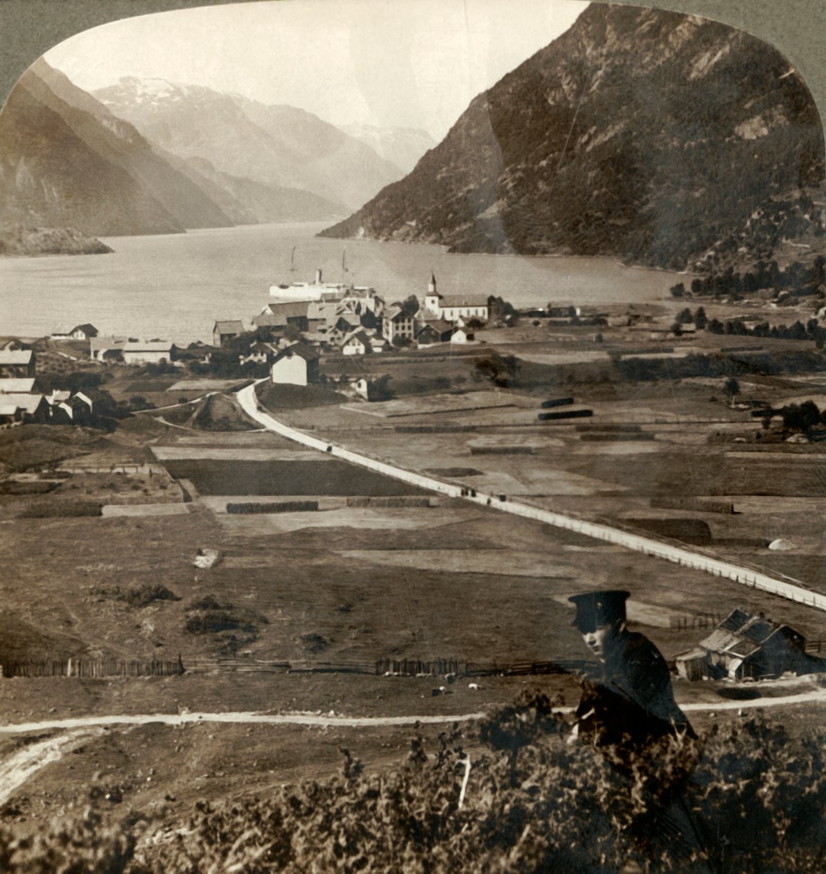Kylän katot ja aurinkoiset kentät Odden N. kapealla vuori-seinämäisellä Sorfjordilla, Norjassa, 1905. tekijältä Unbekannt