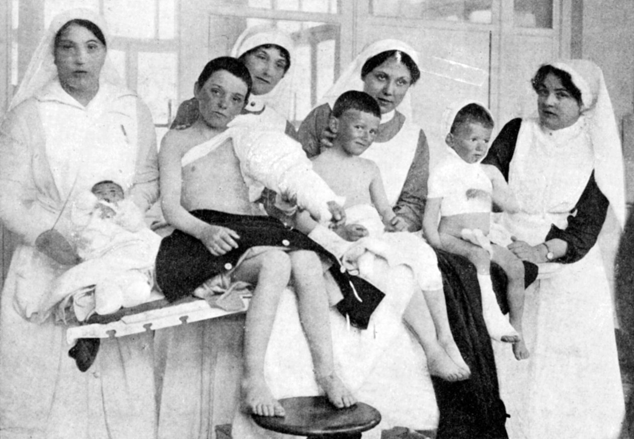 Haavoittuneet lapset Ypresistä sairaanhoitajien kanssa La Pannessa, Belgiassa, ensimmäinen maailmansota, 1914-1918, c1920 tekijältä Unbekannt