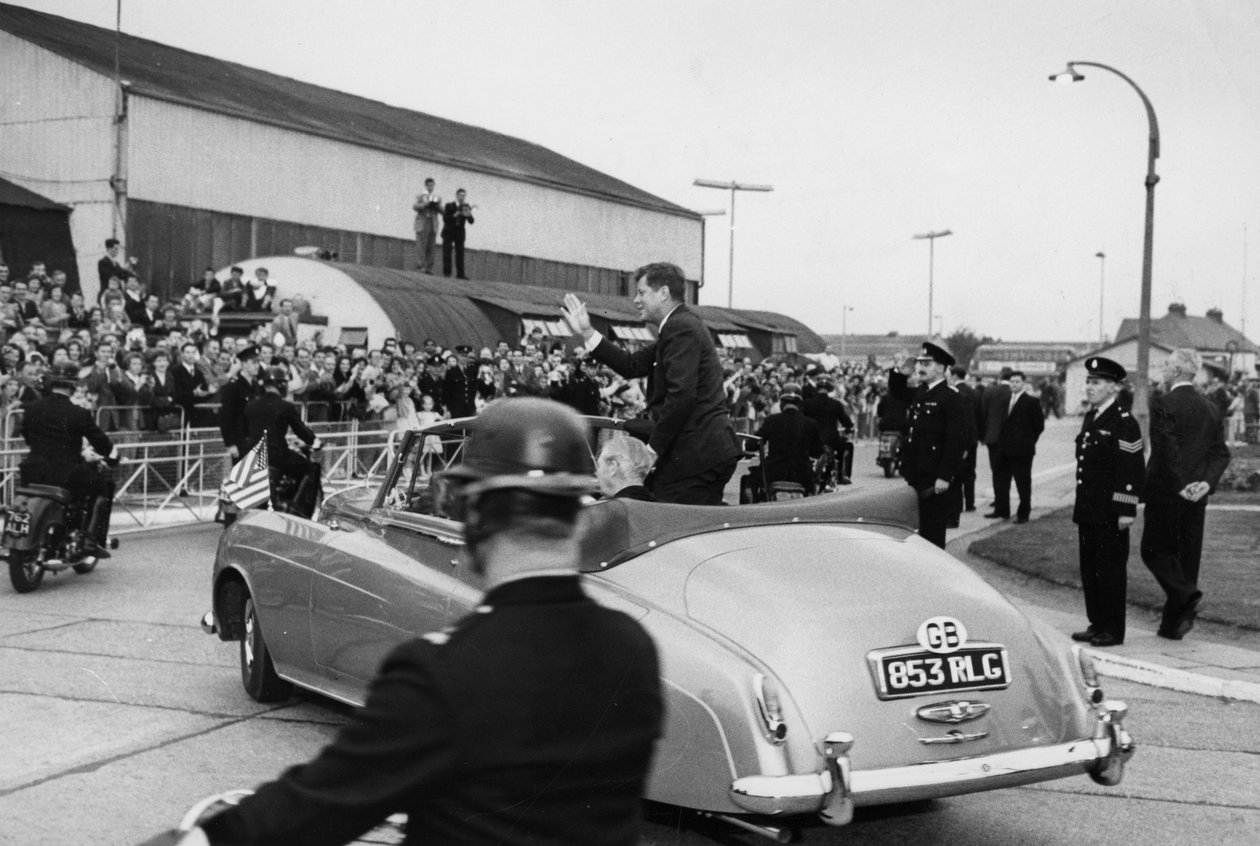 Tarkastettuaan laivaston kunniakaartin Lontoon lentokentällä presidentti Kennedy ja herra Macmillan ajavat pois avoimella autolla. tekijältä Unbekannt