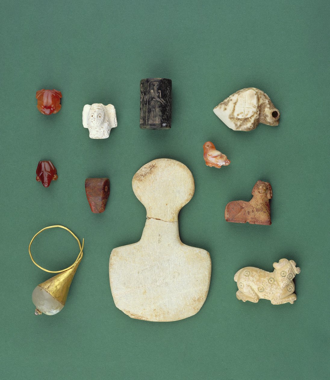 Kokoelma itäisen Välimeren esineitä, mukaan lukien sumerilainen korppikotka-amuletti, akkadilainen käärmehylje ja Mesopotamian karneoli-sammakko, vuosilta 3300-2000 eaa. tekijältä Unbekannt