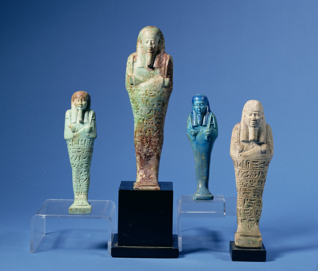 Neljä vihreää tai sinistä lasitettua shabti-hahmoa, joista kolmessa on vaakasuorat hieroglyfikirjoitukset, egyptiläinen, 7.–3. vuosisadalta eKr. tekijältä Unbekannt