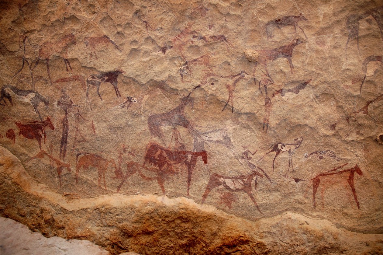 Kalliotaide, esihistoria: Kalliomaalaus karjaryhmästä ja monivärisistä hahmoista (paimenet ja jousimiehet) koristeellisessa suojissa Uweinatin vuoristossa, Sudanissa. Ajanjakso 8000-3000 vuotta eKr. Valokuvaus tekijältä Unbekannt