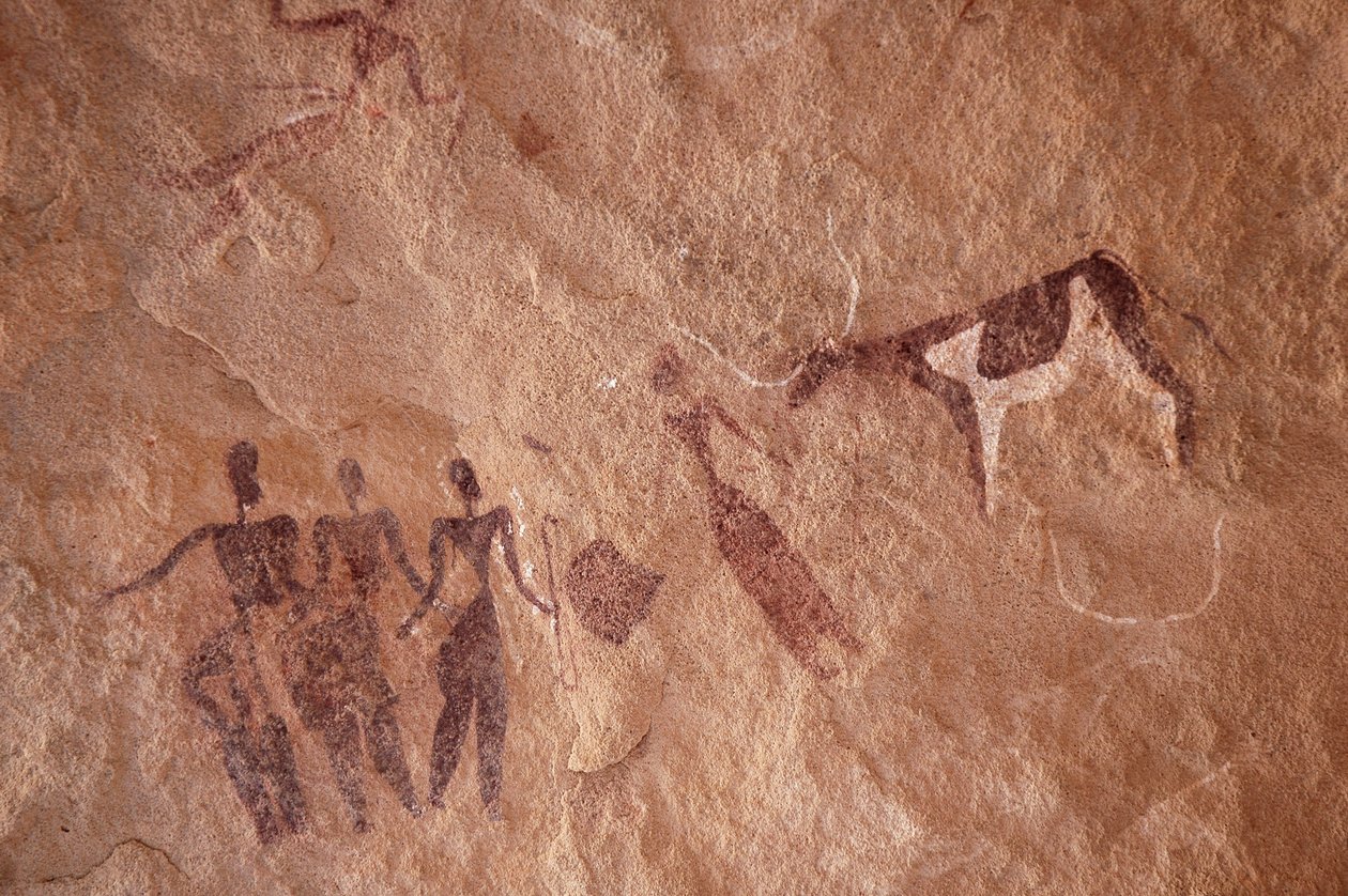 Kalliotaide, esihistoria: Kalliomaalaus hahmoryhmästä ja kaksisävyisestä lehmästä, jolla on suuret sarvet koristeellisessa suojissa Uweinatin vuoristossa, Egyptissä. (Ajanjakso 8000-3000 vuotta eKr.). Valokuvaus tekijältä Unbekannt