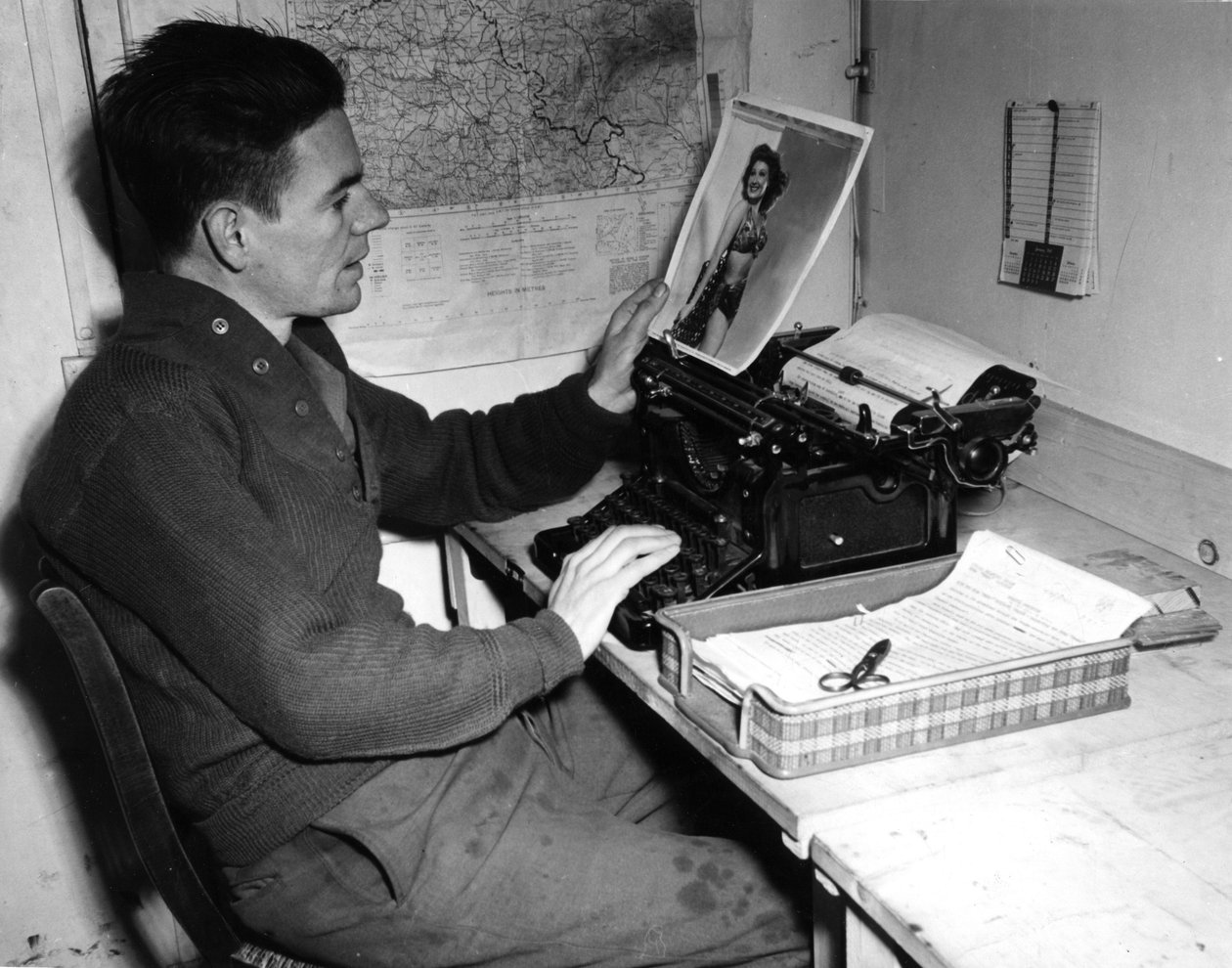 Toinen maailmansota (1939-1945) – Toinen maailmansota (toinen tai toinen maailmansota): Mutzig (Alsace) Ranska 1. joulukuuta 1944: Beachead Newsin (GI:n uutislehti) korpraali Flanertyn kronikoitsija katsoo pin-up-valokuvaa, jonka hän julkaisee lehden seura tekijältä Unbekannt