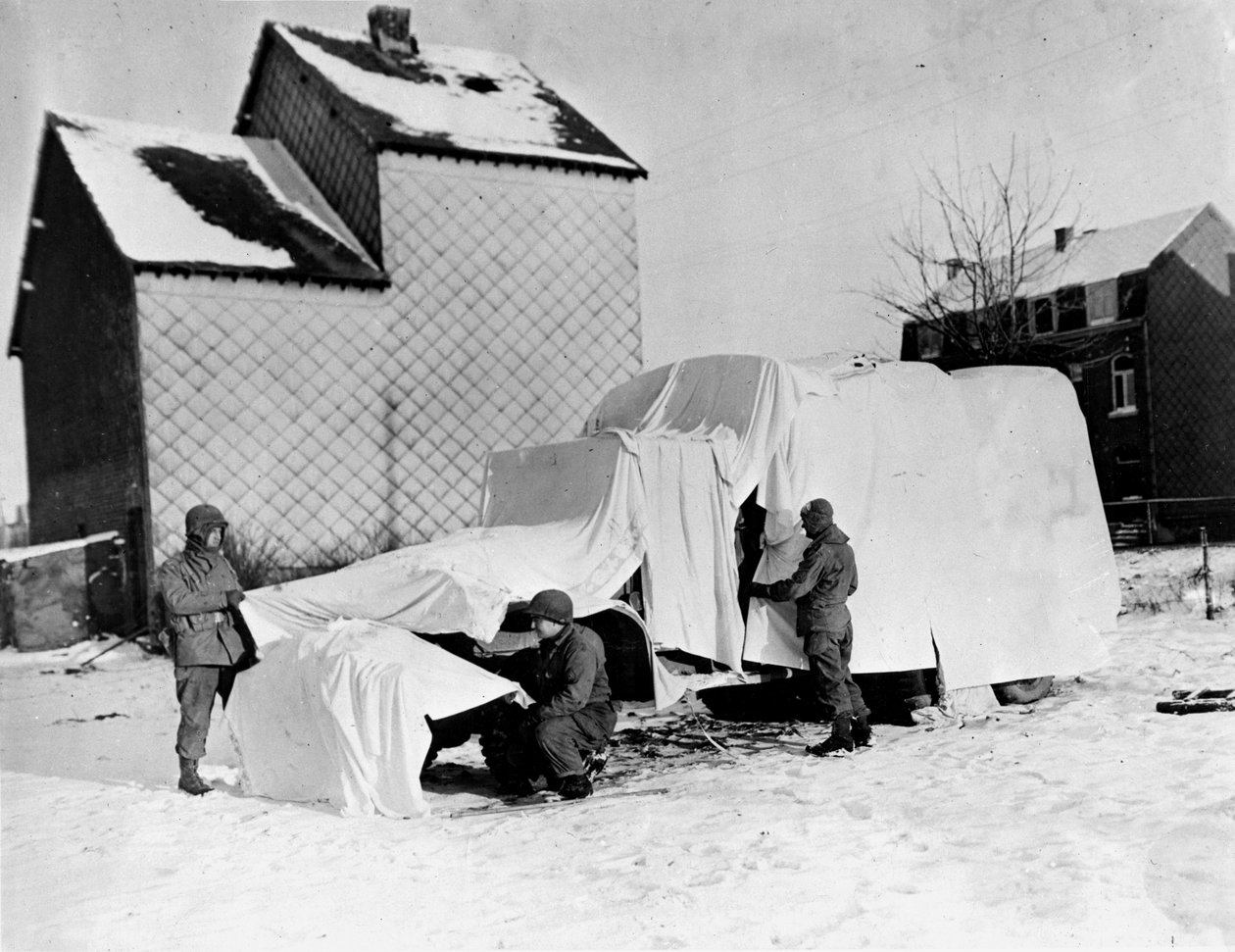 Toinen maailmansota (1939-1945) - Toinen maailmansota (WWII tai WW2): Lähellä Bastognea (Belgia) joulukuun lopussa 1944: Nämä amerikkalaiset sotilaat käyttävät valkoisia lakanoita piilottaakseen kuorma-auton vihollisen silmissä tekijältä Unbekannt