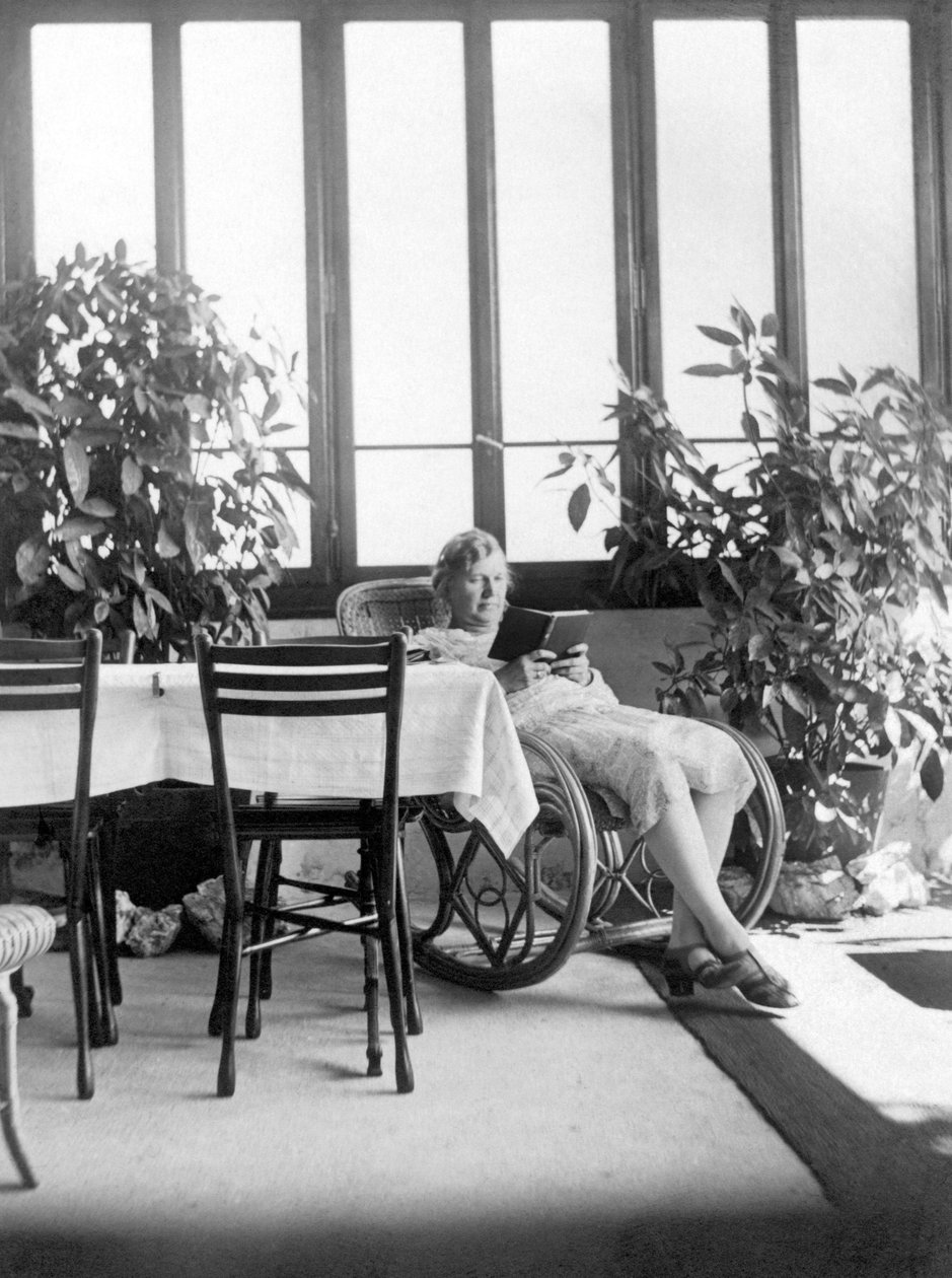 Nainen istuu keinutuolissa lukemassa kirjaa. 1915 n. Saksa Historiallinen valokuva, nainen lukemassa, n. 1915. tekijältä Unbekannter Künstler