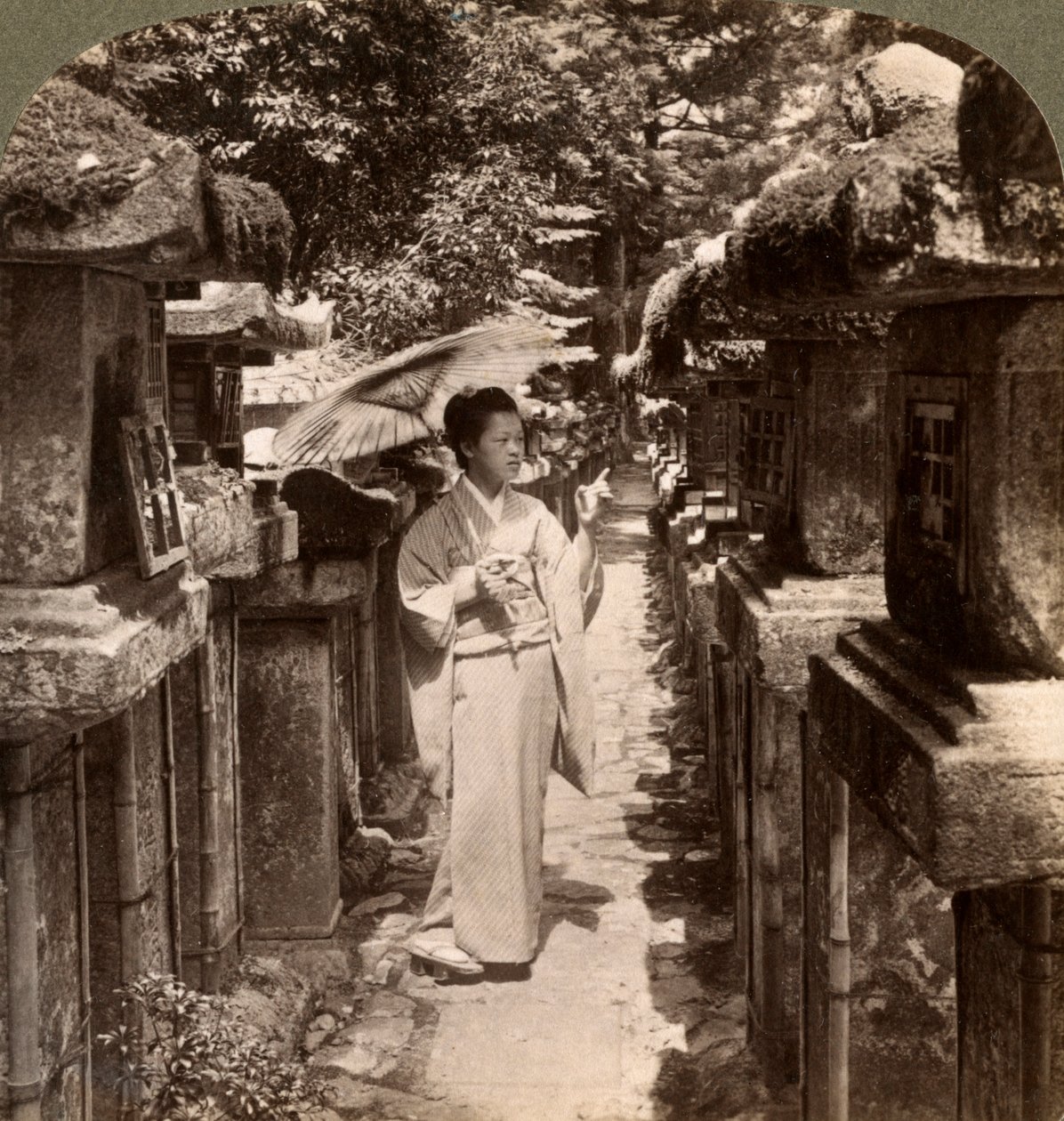 Nainen shinto-harrastaja laskemassa kivilyhtyjä, Kasugan pyhäkkö, Nara, Japani, 1904. tekijältä Underwood and Underwood