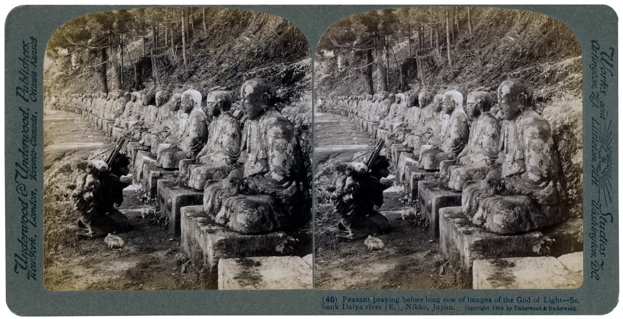 Talonpoika rukoilee valojumala-patsasrivin edessä, Daiya-joki, Nikko, Japani, 1904. tekijältä Underwood and Underwood