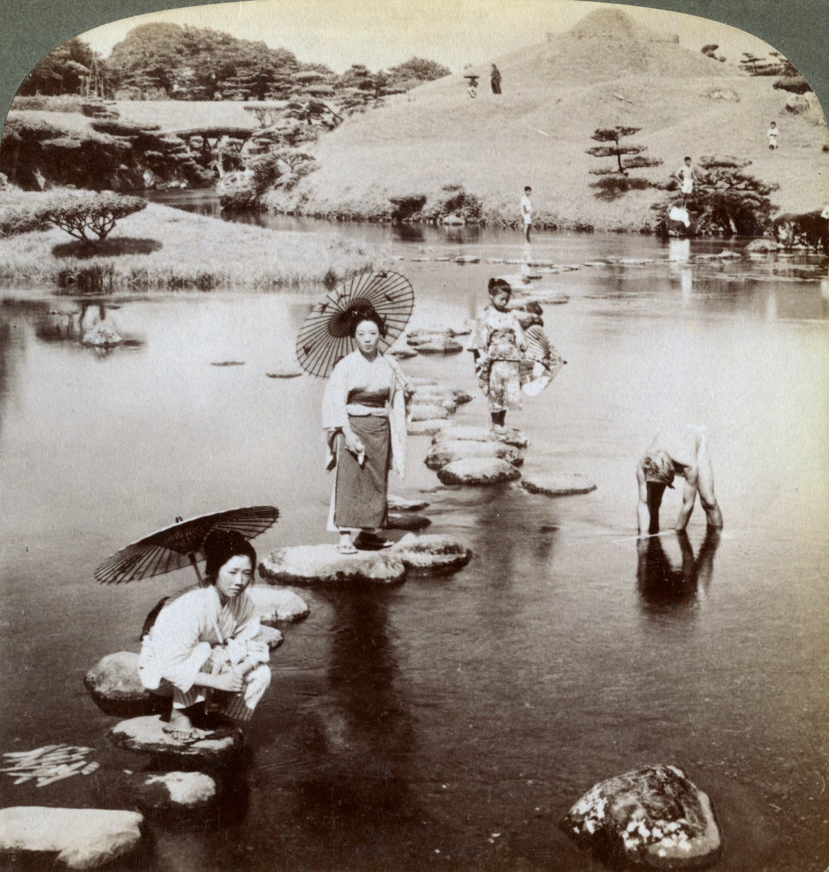 Naiset ylittävät järven ponnahduskivillä, Suizen-ji Garden, Kumamoto, Japani, 1904. tekijältä Underwood and Underwood