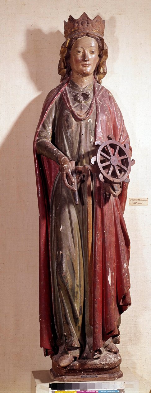 Kuvaus Pyhästä Katariinasta Aleksandriasta pitelemässä piinansa pyörää. Monivärinen puinen patsas tekijältä Unknown artist