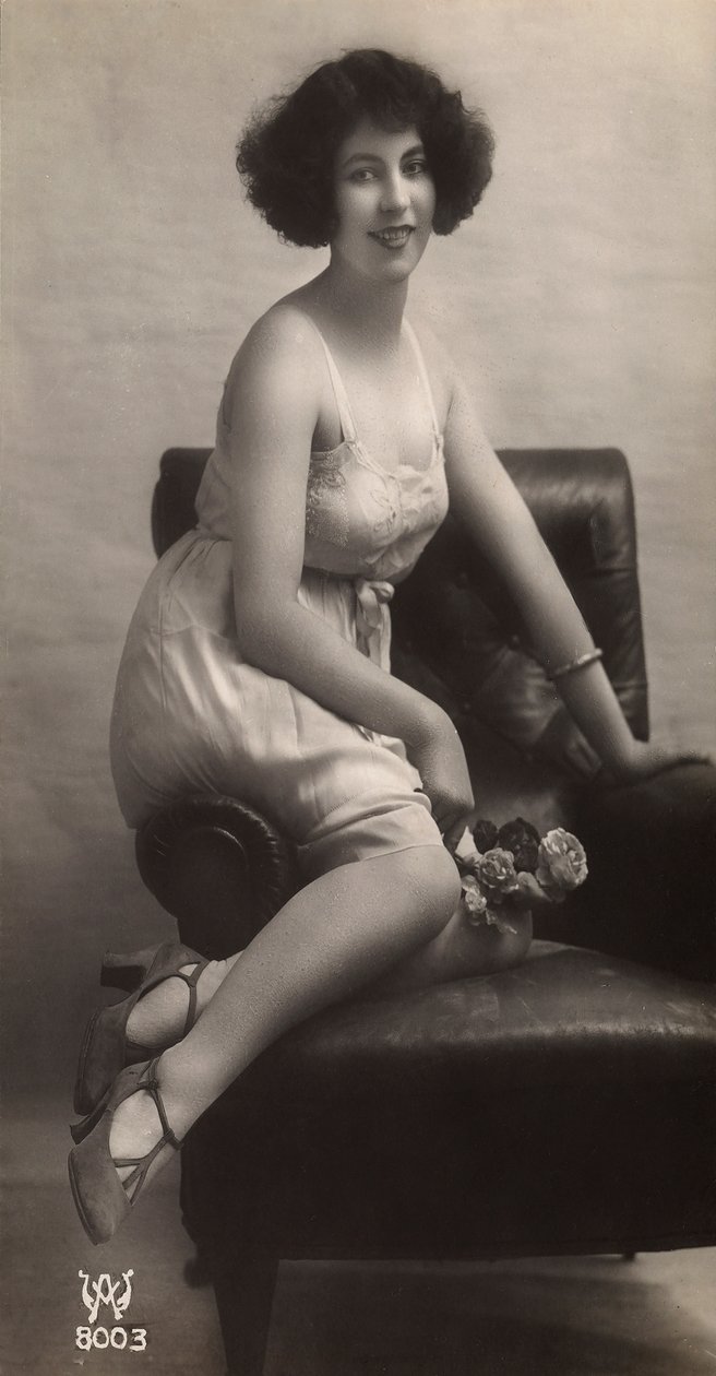 Nuori nainen poseeraa alushameessaan, istuu nojatuolissa. tekijältä Unknown photographer
