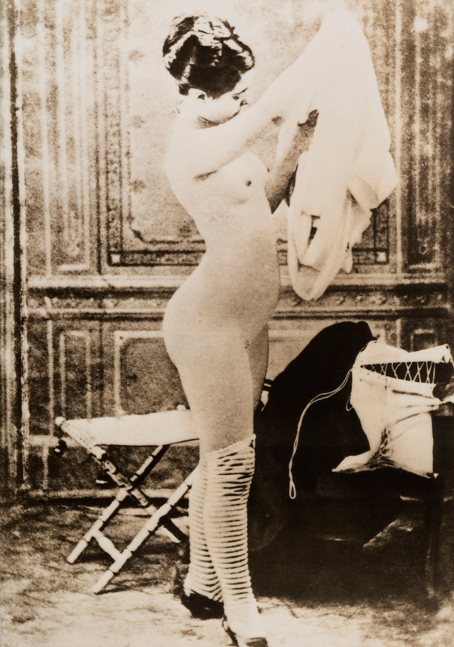 Täyspitkä alaston muotokuva pukeutuvasta nuoresta naisesta. tekijältä Unknown photographer