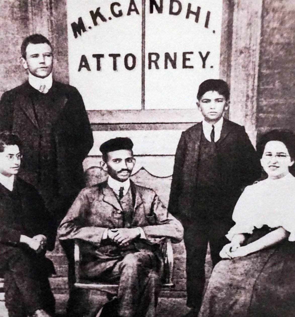 Mahatma Gandhi istuu neljän työtoverinsa kanssa asianajajan lakitoimistonsa edessä Johannesburgissa, Etelä-Afrikassa, Etelä-Afrikassa. tekijältä Unknown photographer