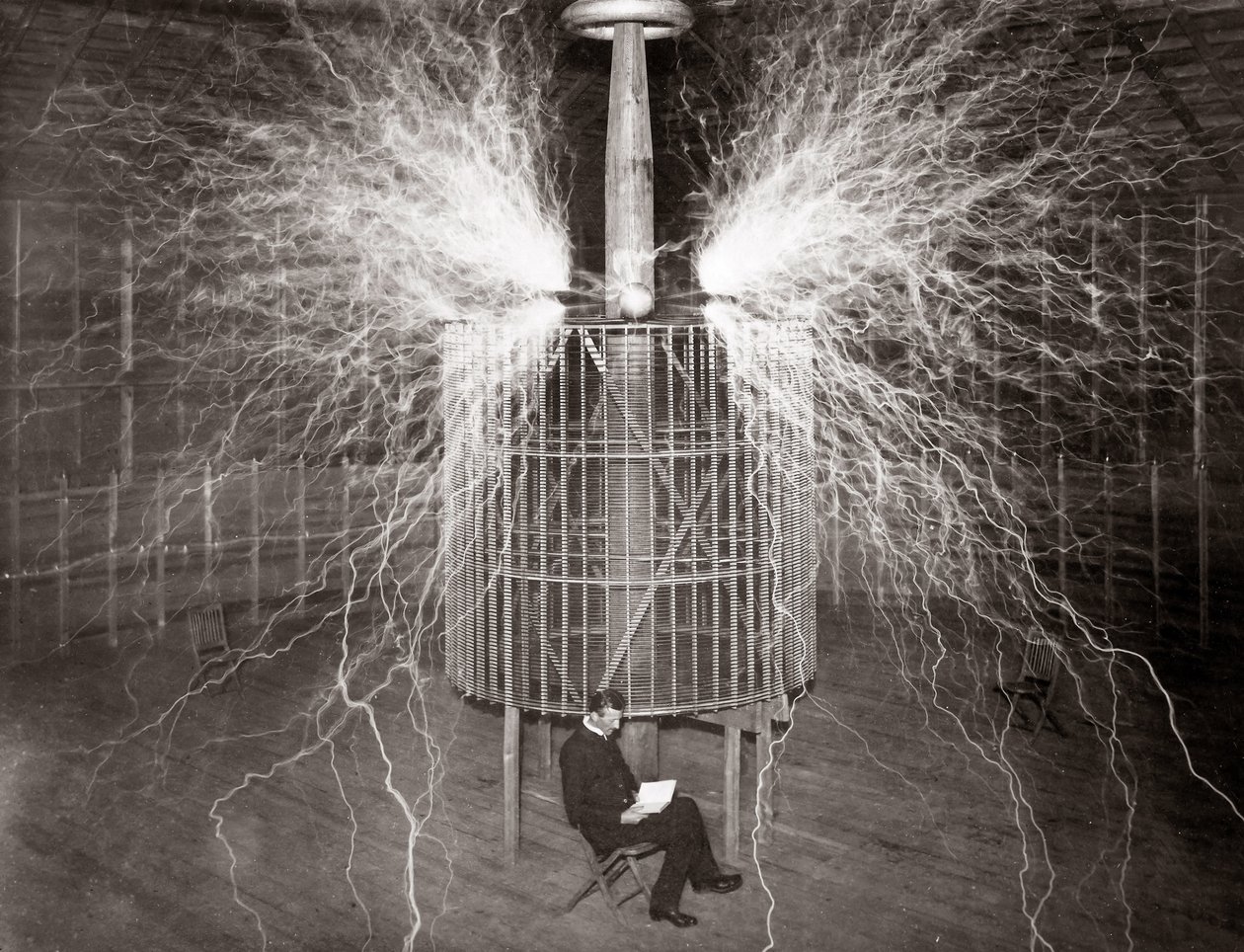 Nikola Tesla istuu Colorado Springsin laboratoriossa "suurennuslähettimensä" kanssa tekijältä Unknown photographer