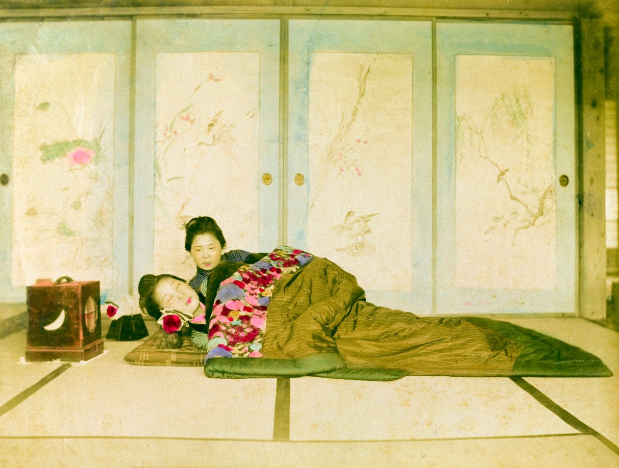 Makuuasento futonilla. Kaksi japanilaista naista makaa lattialle asetetulla perinteisellä futonilla. Japani, noin 1910. Japani, Itä-Aasia, Aasia. ©Cultural Heritage Images/UIG/Leemage. tekijältä Unknown photographer