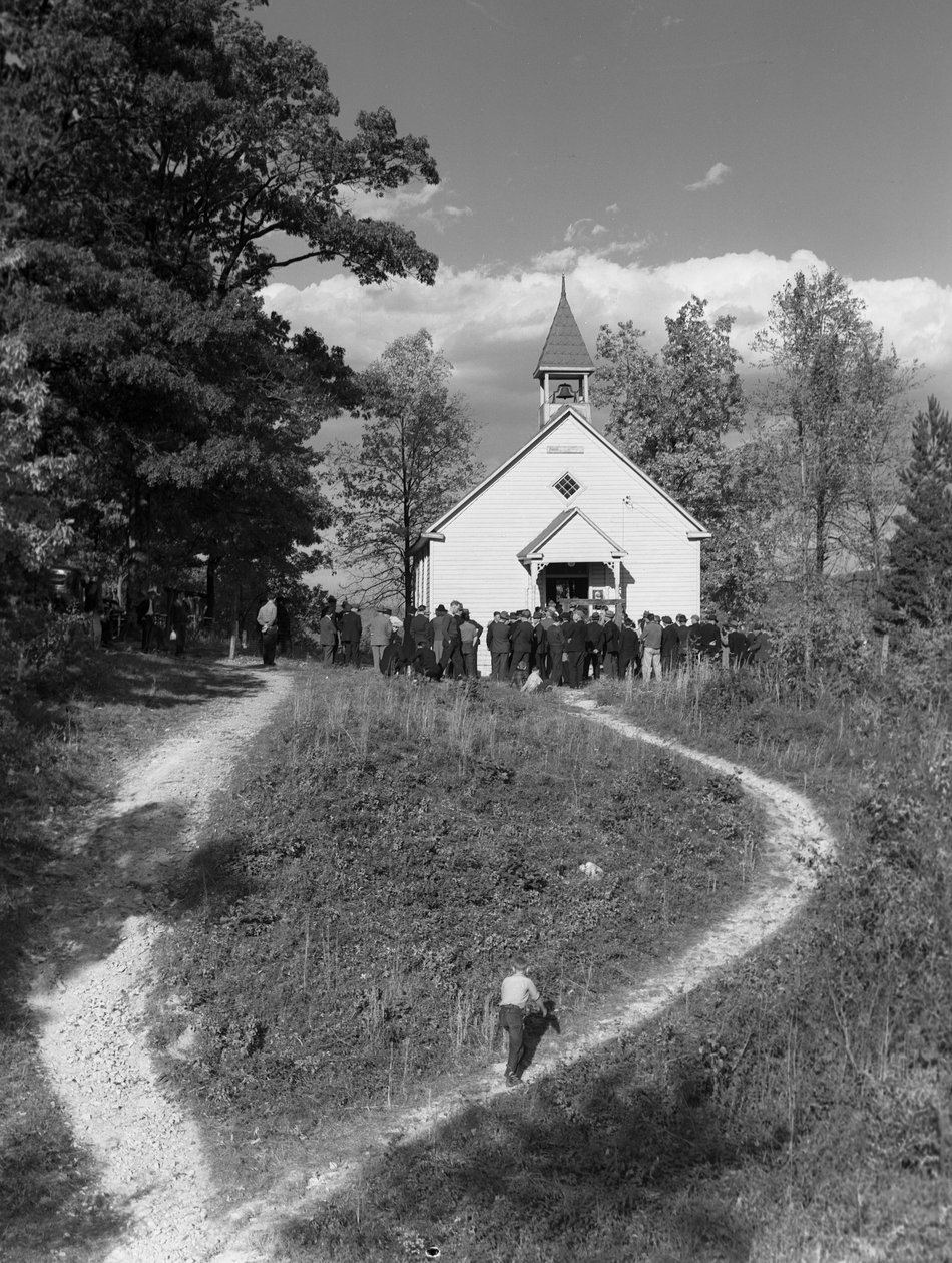 Miehet kokoontuivat pienen maaseuturakennuksen, koulutalon tai kirkon ulkopuolelle, jossa oli kello.... tekijältä Volkmar Wentzel