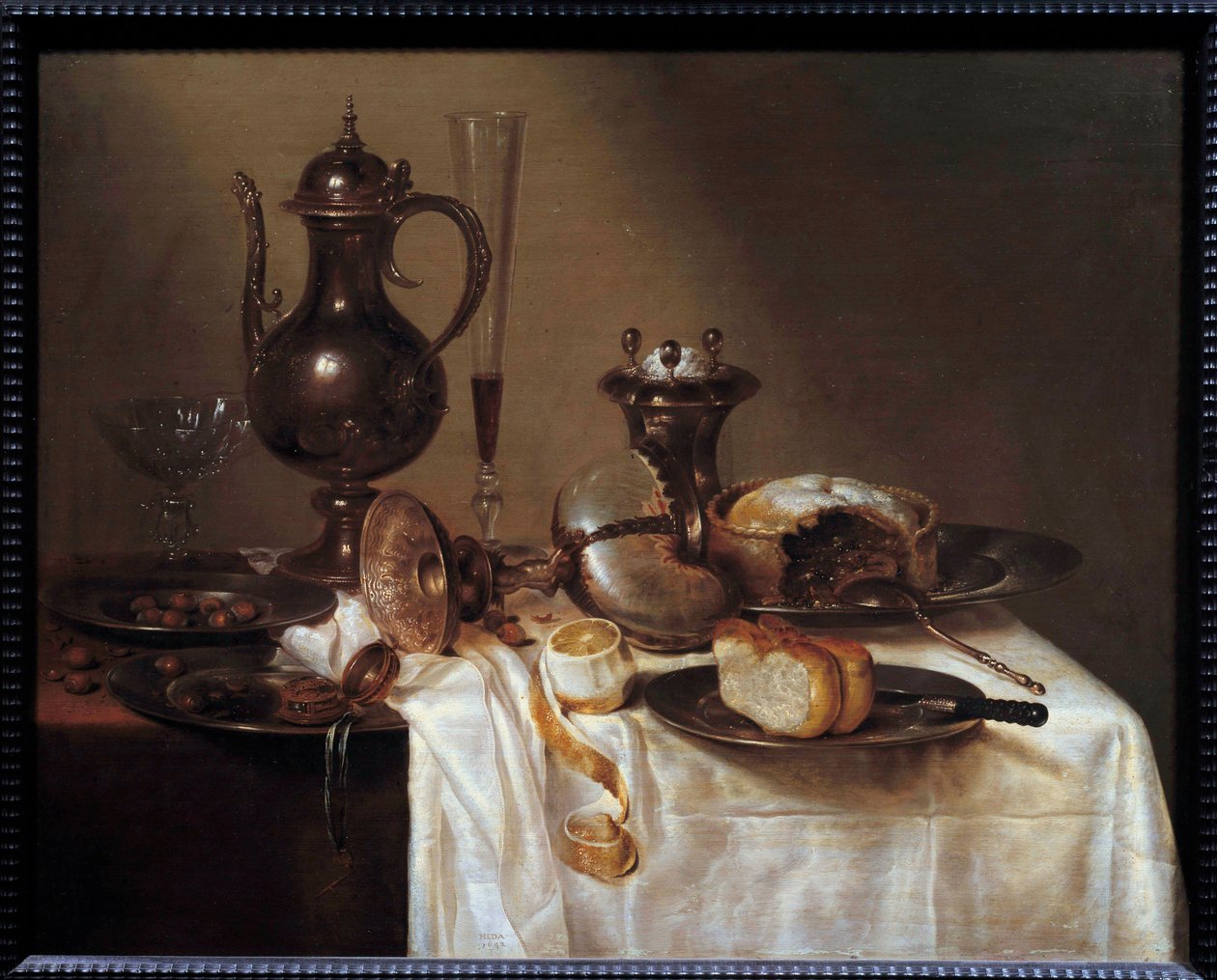 Asetelma meripeninkulman ääressä hopeaesineillä, leivällä, viinihuilulla, piirakalla ja kuoritulla sitruunalla katettu pöytä. Willem Hedan (1594-1670) maalaus 1642 Saint Etienne, Kuvataidemuseo tekijältä Willem Claesz. Heda