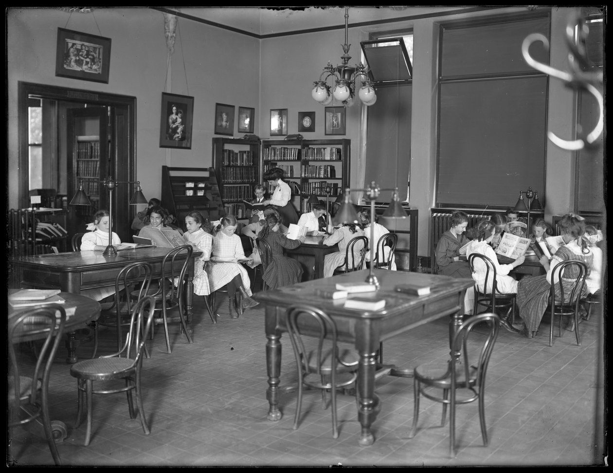 Lapset lukevat Queens Borough Public Libraryn tunnistamattoman haaran lukusalissa, n. 1910 tekijältä William Davis Hassler