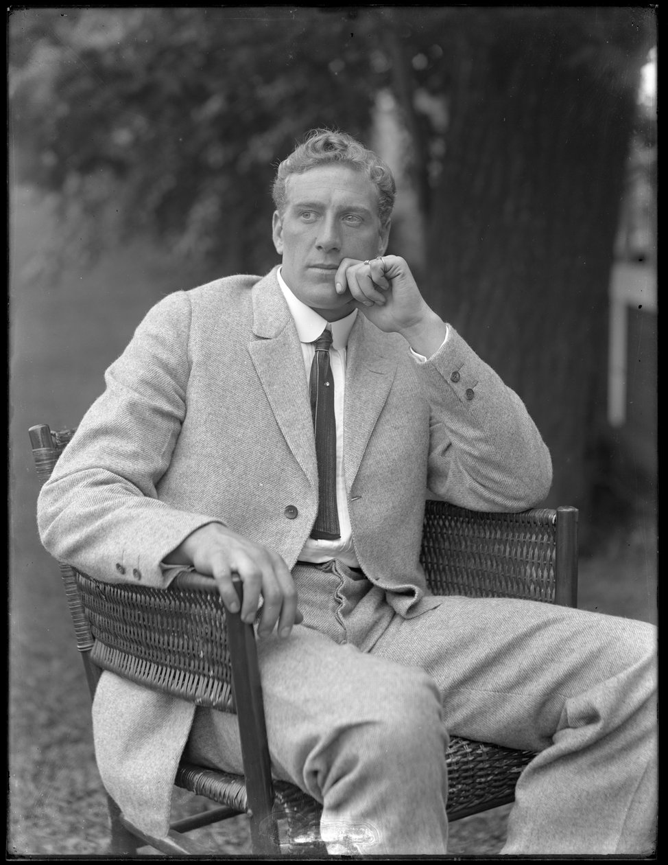 Englantilainen nyrkkeilijä William Thomas Wells (Bombardier Billy Wells), poseerasi istuen tweed-puvussa, n. 1911 tekijältä William Davis Hassler