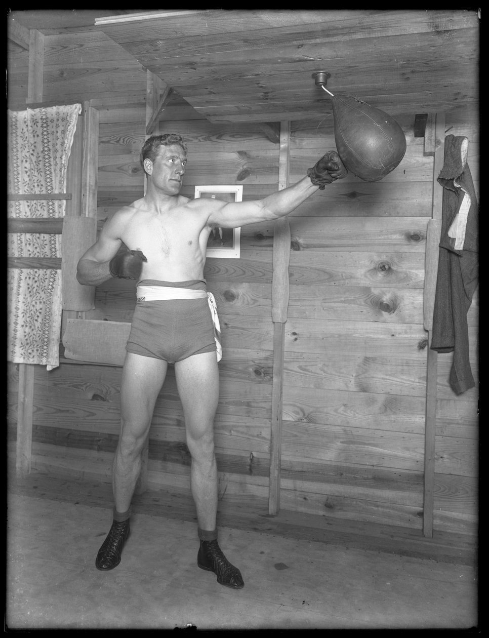 Englantilainen nyrkkeilijä William Thomas Wells (Bombardier Billy Wells), poseeraa harjoitustakeissa nopeuslaukun kanssa, n. 1911. tekijältä William Davis Hassler