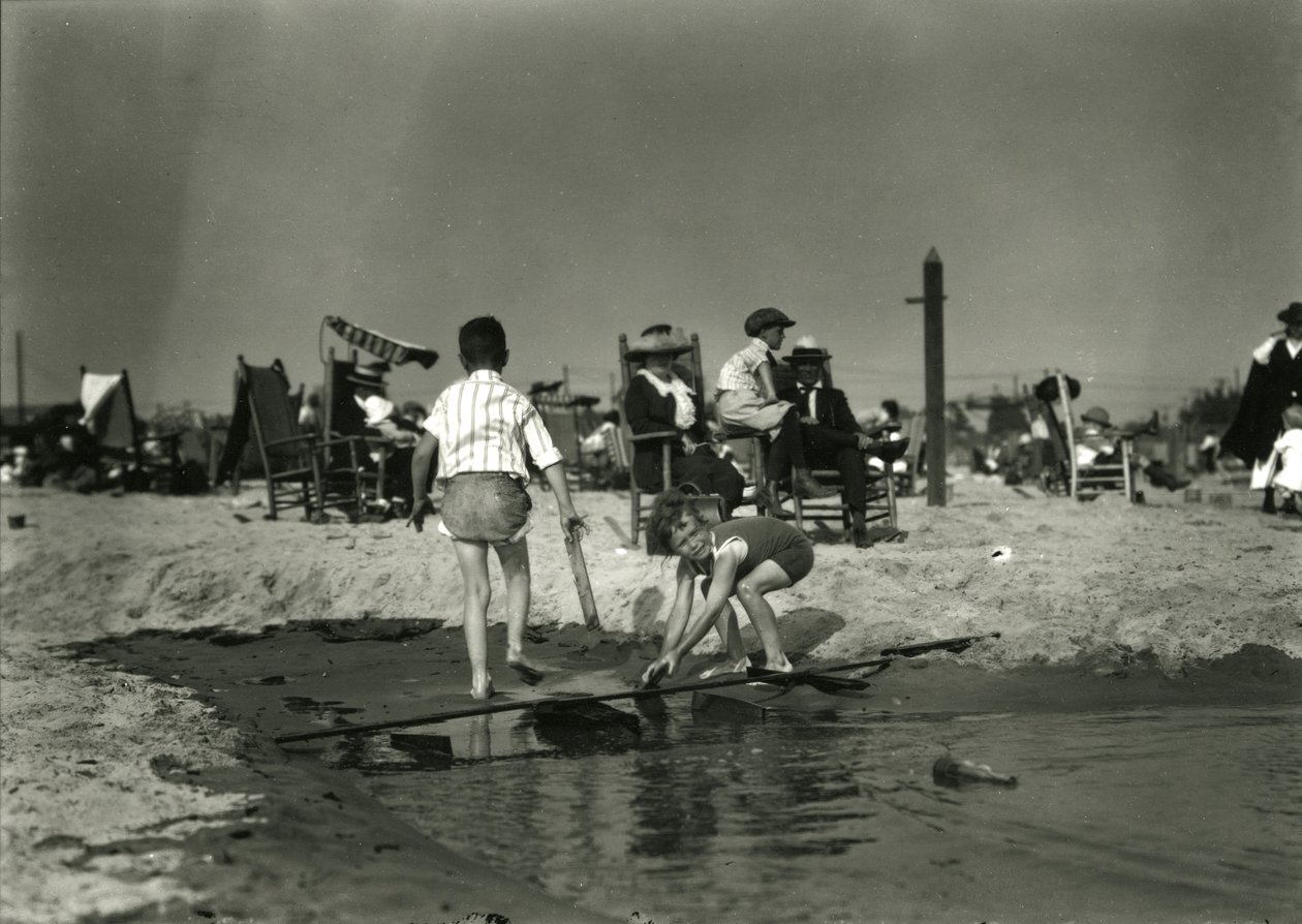 Kaksi lasta leikkii puujätteillä matalikossa, Coney Island, n. 1910-21 tekijältä William Davis Hassler