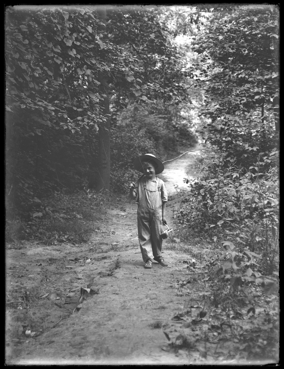 William Gray Hassler olkihatussa ja haalareissa, onkivapa ja kori kantamassa, kävelemässä polkua metsässä yksin, 20. elokuuta 1911 tekijältä William Davis Hassler