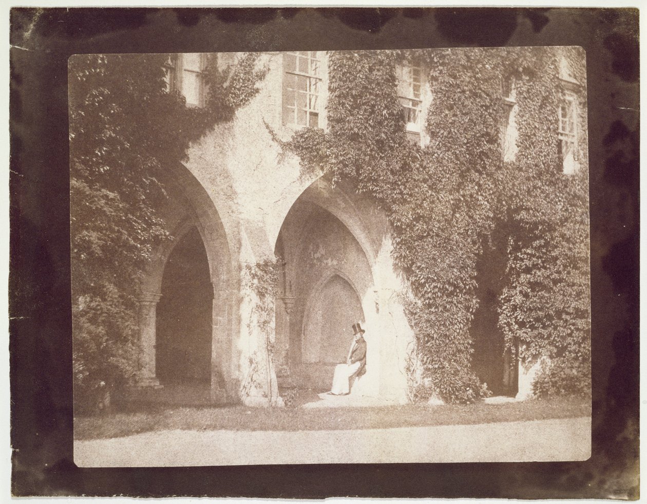 Pastori Calvert Jones istuu Cloistersissa, Laycock Abbeyssa, n. 1847 (suolapaperiprintti kalotyyppinegatiivista) tekijältä William Henry Fox Talbot