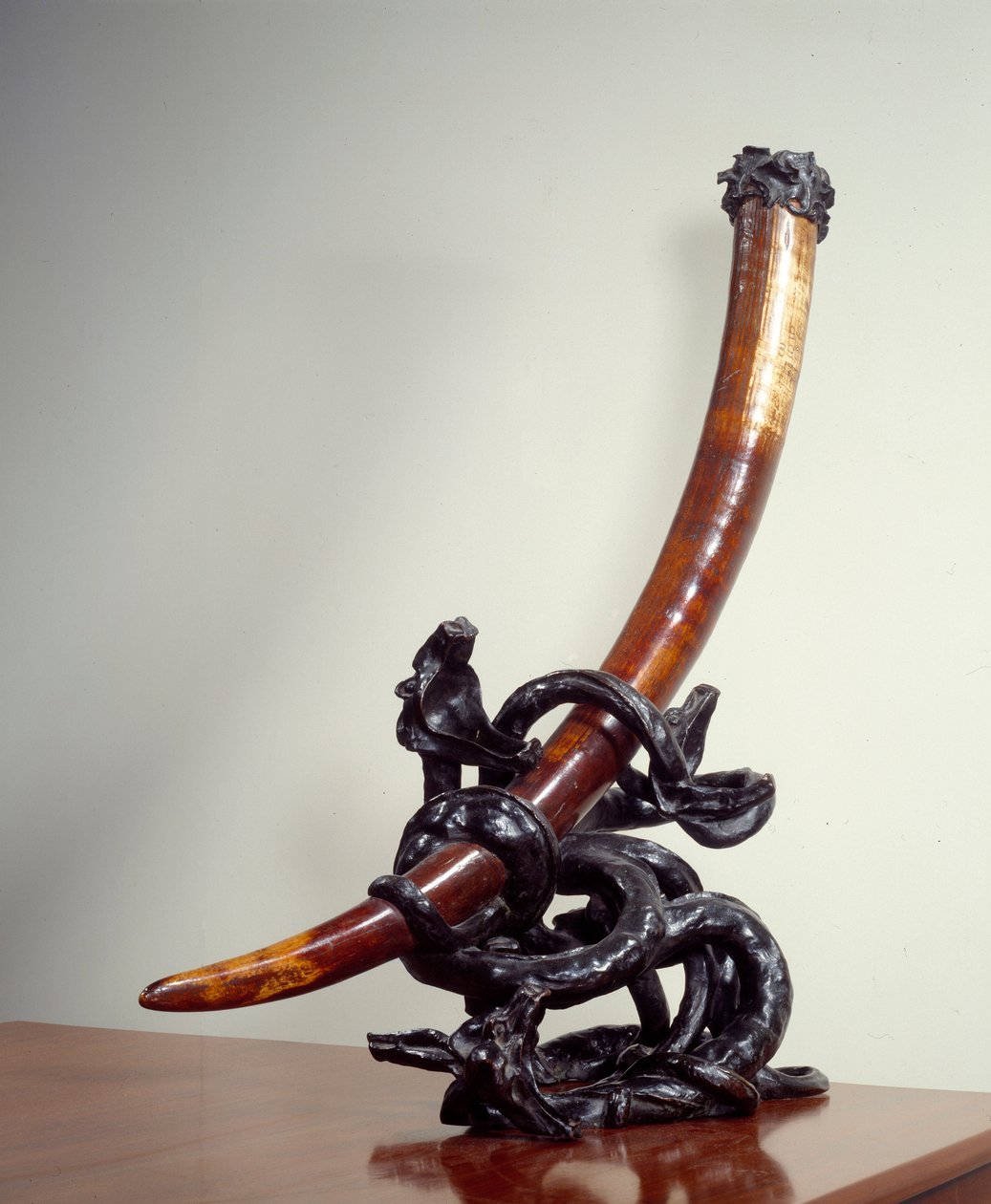 Hyvän ja pahan taistelu. Elefanttipuolustukseen kiinnitetty norsunluupronssipatina. Toteuttanut Leopold Van Strydonck (1861 - 1937) tekijältä William van Strydonck