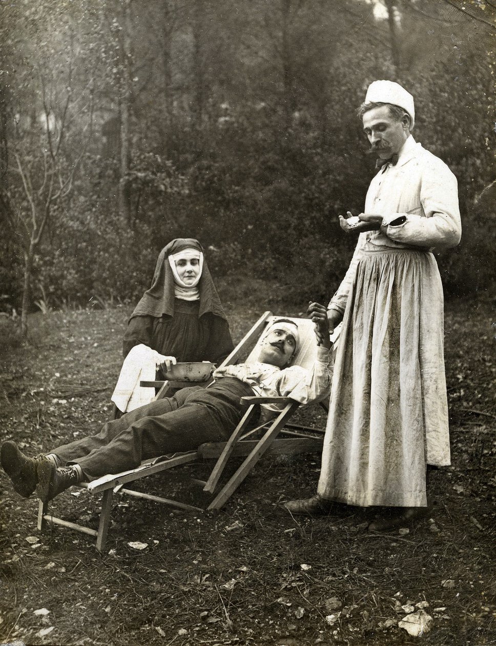 Lääkäri mittaa loukkaantuneen miehen pulssia sairaanhoitajan apuna, noin 1900 (m/v kuva) tekijältä . .