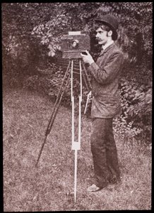 Omakuva kameralla, jalustalla ja pistoolilla tekijältä Alfred Stieglitz