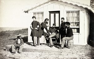 Viisi sisällissodan sotilasta kokoontui likakuistille kodin ulkopuolelle, afroamerikkalaiset nuoret istuivat heidän lähellään, 1861-65 tekijältä American Photographer