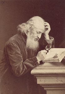 [Parrakas mies suurennuslasilla tutkimassa käsikirjoitusta], 1870-luku.