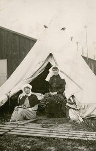 Sisar Eleanor Wibmer Jeffries ja sisar Nellie Constance Morrice (oikealla) telttansa ulkopuolella Australian yleissairaalassa nro 3 kukkien kanssa, jotka on poimittu Sommen rannalta, n. kesäkuuta 1917 (bw kuva tekijältä Australian Photographer