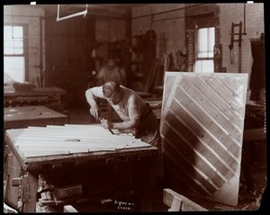 Mies työskentelee Hardman, Peck und Co:n pianotehtaalla, New York, 1907 (hopeagelatiiniprintti) tekijältä Byron Company