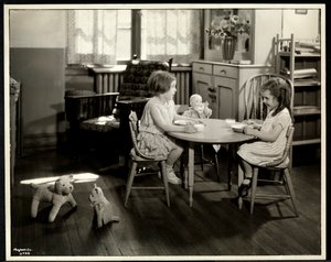 Kaksi sokeaa näkövammaista tyttöä syömässä pienen pöydän ääressä nuken kanssa New York Association for the Blindissa, 111 East 59th Street, New York, 1933 (hopeagelatiiniprintti)