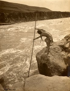 Tlakluit-intiaani, seisoo kalliolla, kalastaa verkolla, n.1910 (s/w valokuva). tekijältä Edward Sheriff Curtis