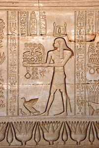 Egyptiläinen antiikki: esitys miehestä, joka tuo uhreja jumalattarelle, Hathorin temppeli, Denderah, Egypti - Egyptin sivilisaatio: mies, joka kuljettaa uhreja jumalatar Hathorille, kaiverrettu Hathorin temppelin (tai Tentyran temppelin) seinälle Denderahi tekijältä Egyptian Ptolemaic Period