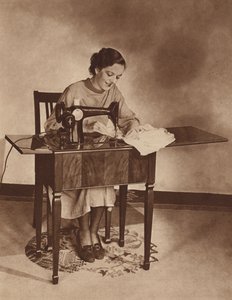 Kotiäiti ompelukoneen ääressä, 1930-luvun puoliväli (s/w-kuva). tekijältä English Photographer