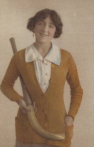 Nätti tyttö, neulepusero, helmikorvakorut, kädessään jääkiekkomaila (kuva) tekijältä English Photographer