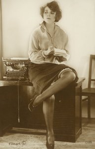 Sihteeri istuu työpöydällä (s/w-kuva) tekijältä English Photographer