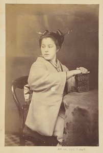 [Istuva japanilainen nainen pitelee pöydän ääressä cartes-de-visite-albumia] tekijältä Felice Beato